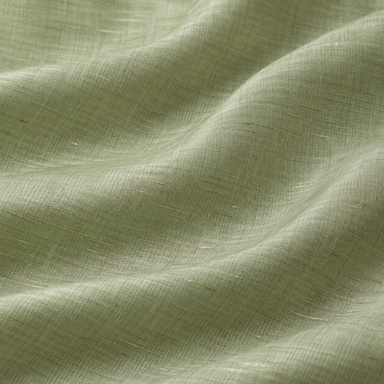 Pale sage silk-cotton fabric with a fine weave and restrained sheen across soft folds.